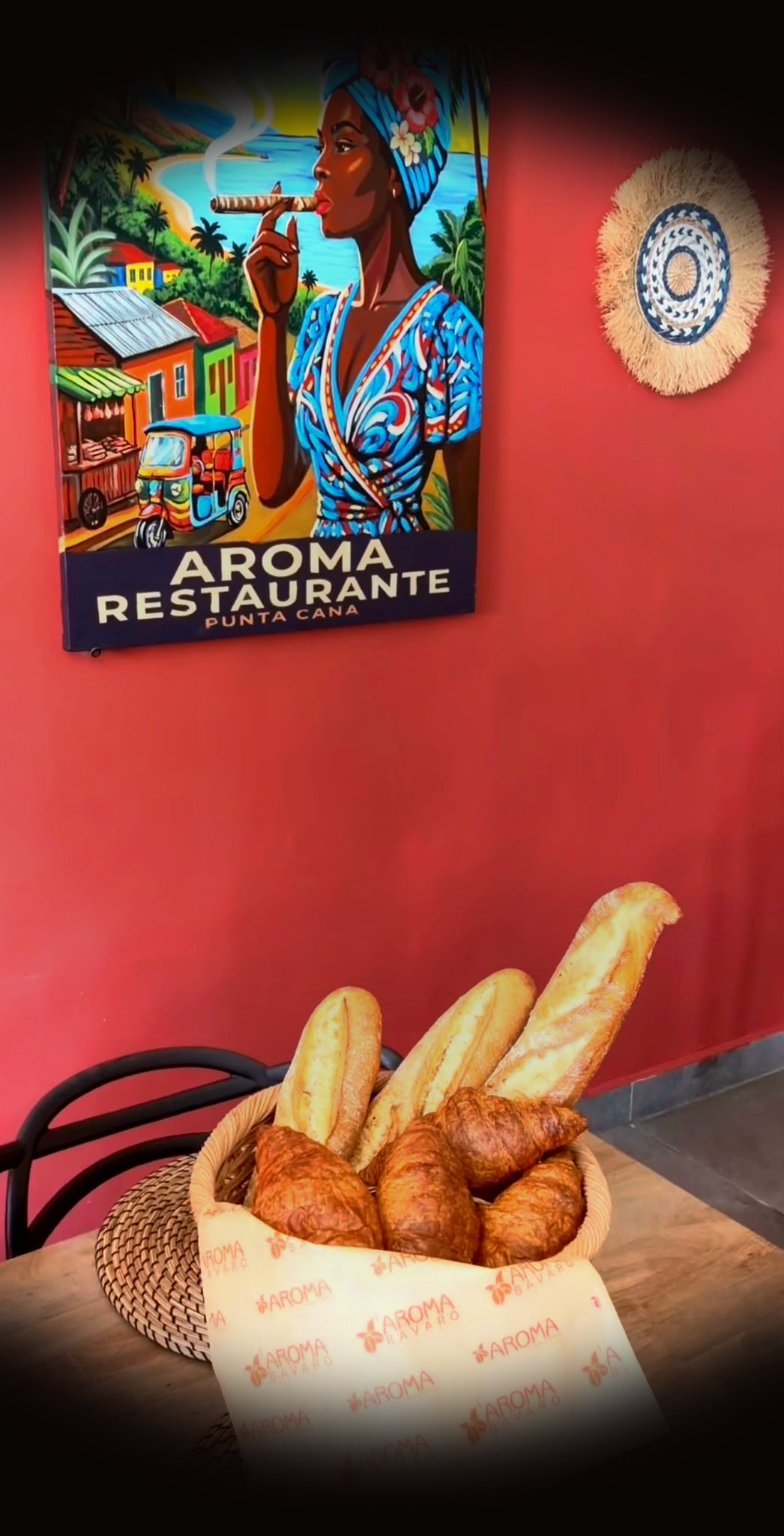 Fresh baguettes and croissants beneath the Aroma mural