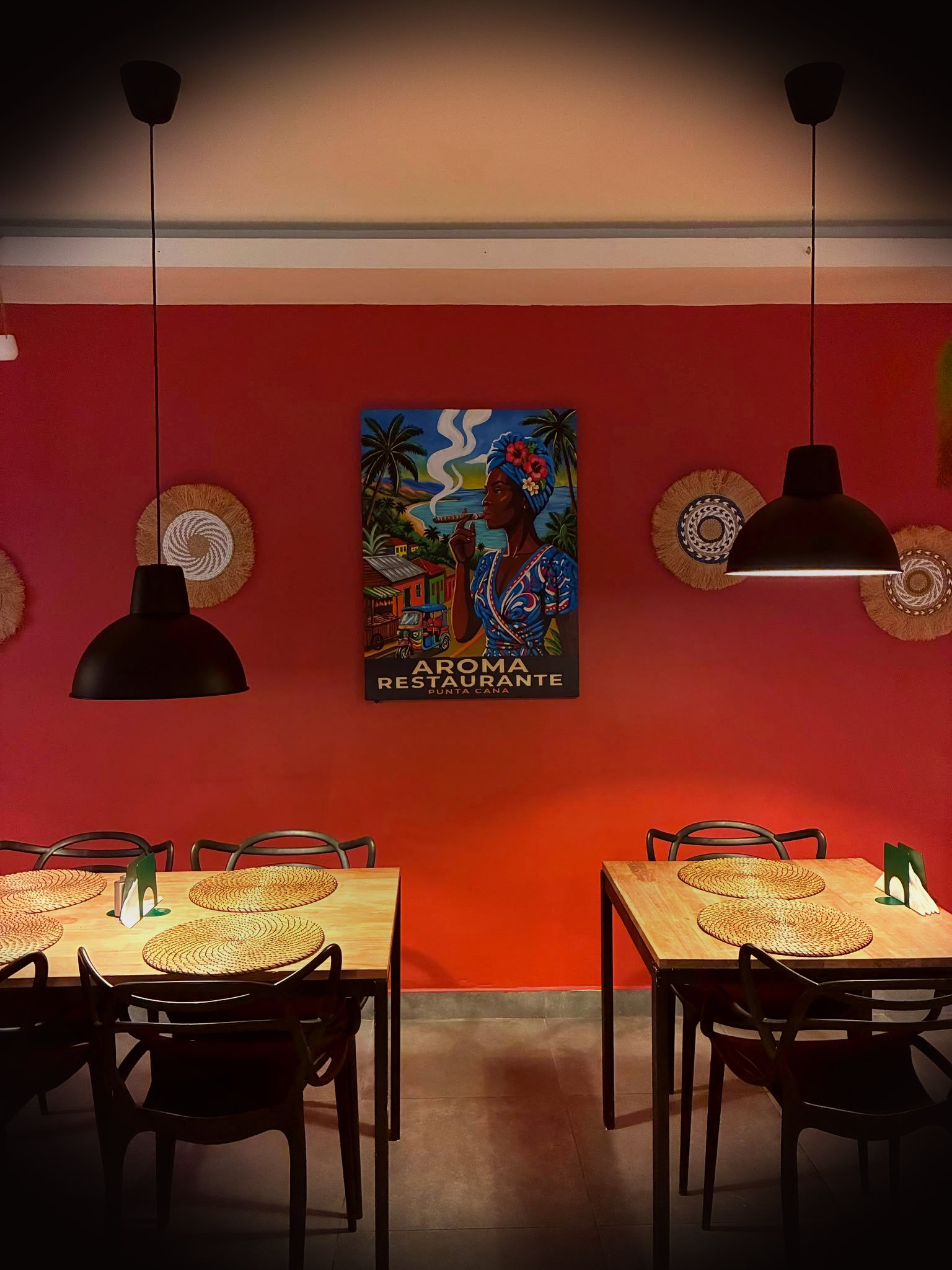 Aroma Restaurante dining room with a hand-painted mural of a woman smoking a cigar on a tropical coastline