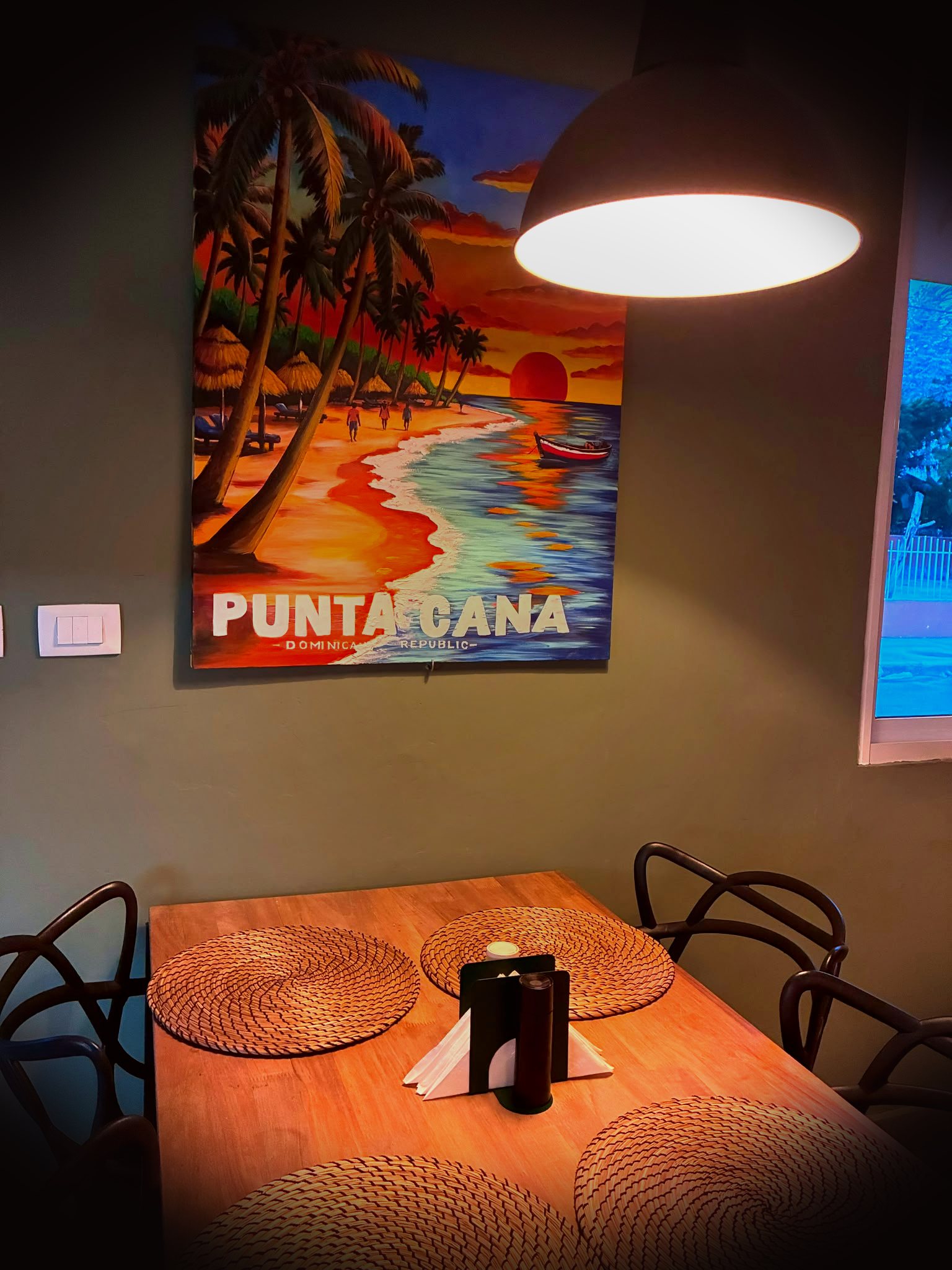 Table set for dinner beneath a Punta Cana sunset mural