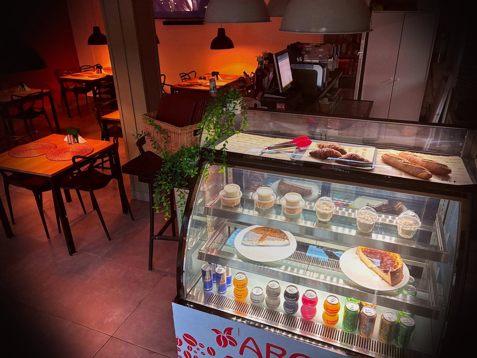 Bakery display case with fresh cheesecake, croissants, and baguettes